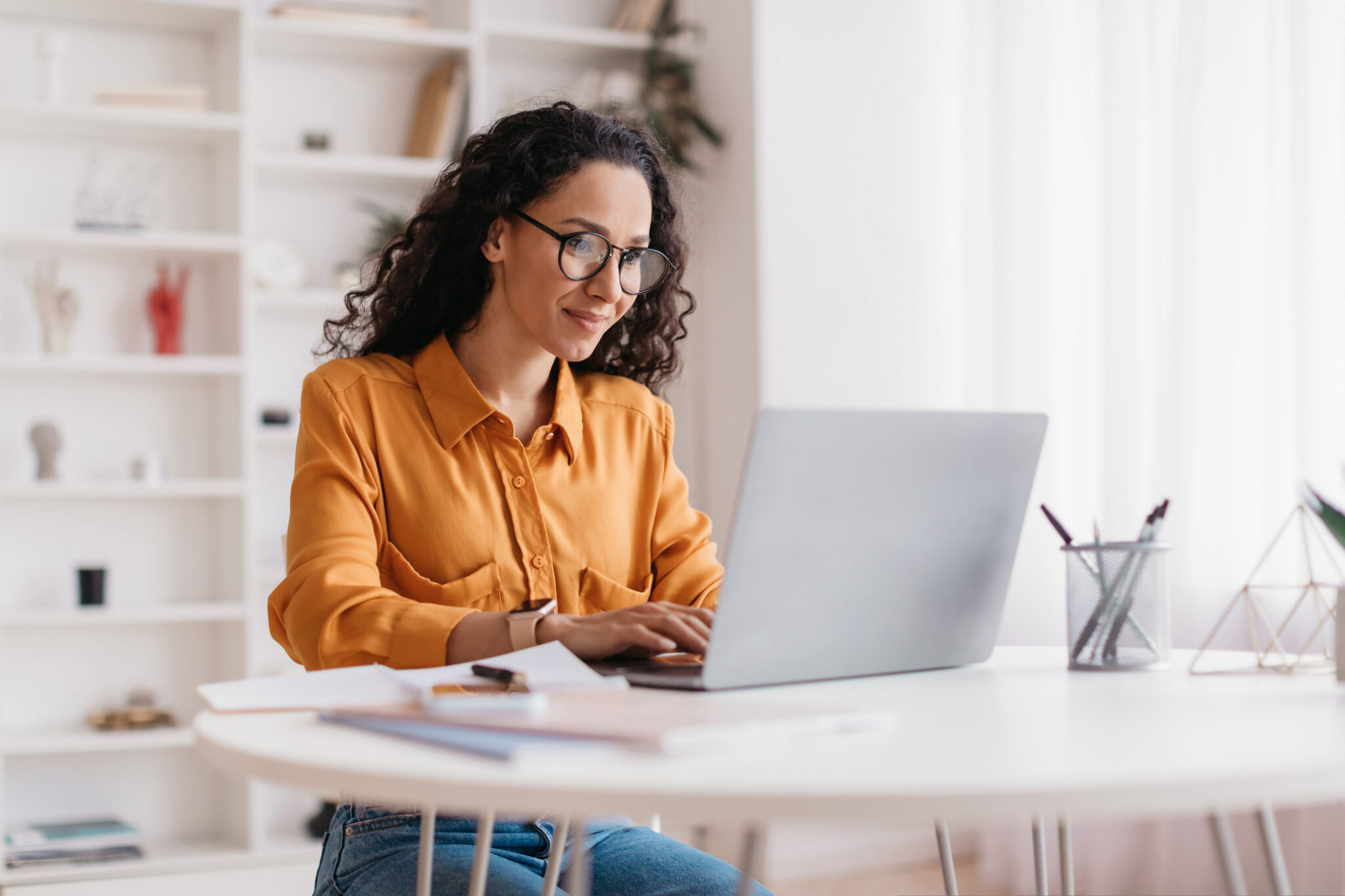Woman working on laptop in home office.